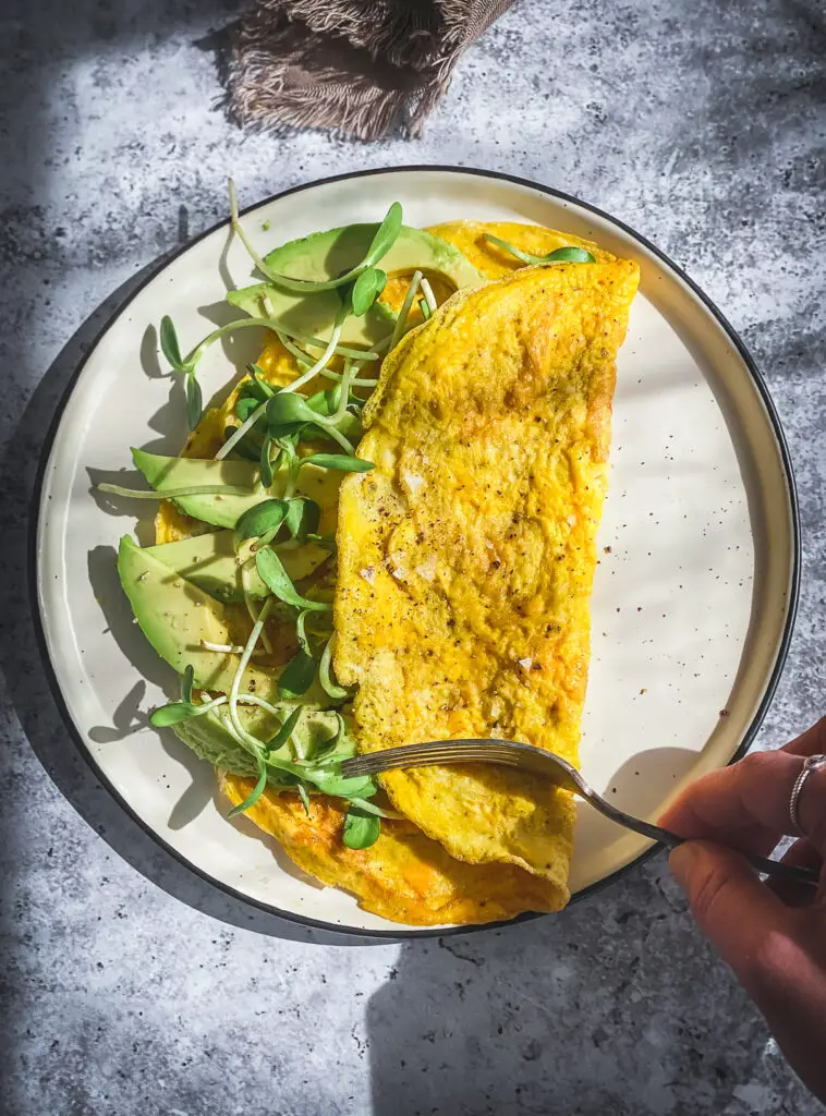 avocado and egg omelette on plate with fork