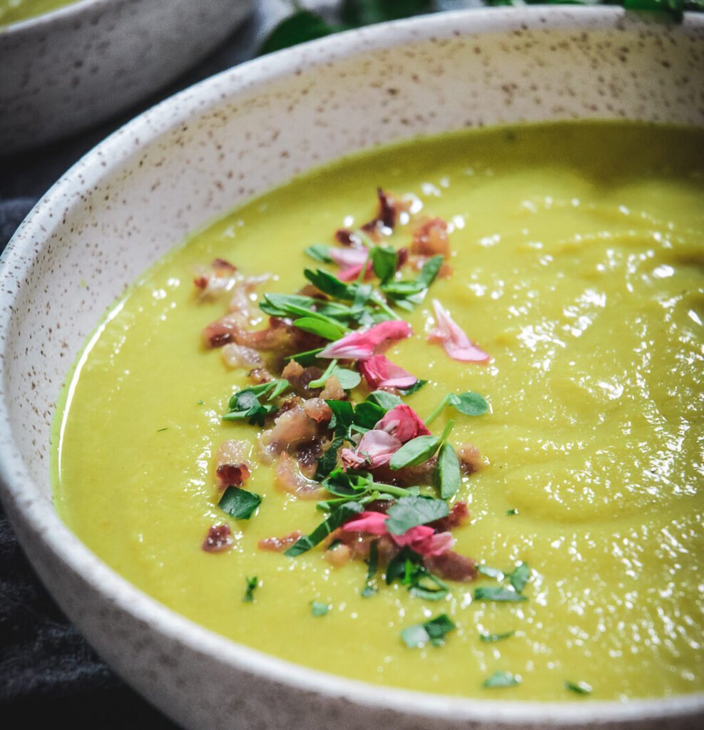 Cauliflower Soup with bacon bits and edible flowers