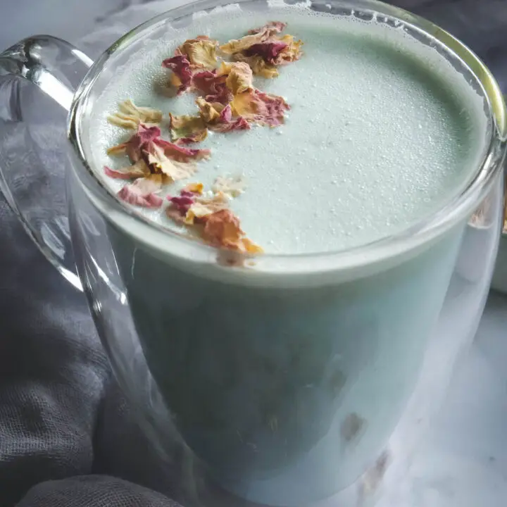 Cardamom Moon Milk in clear mug topped with rose petals