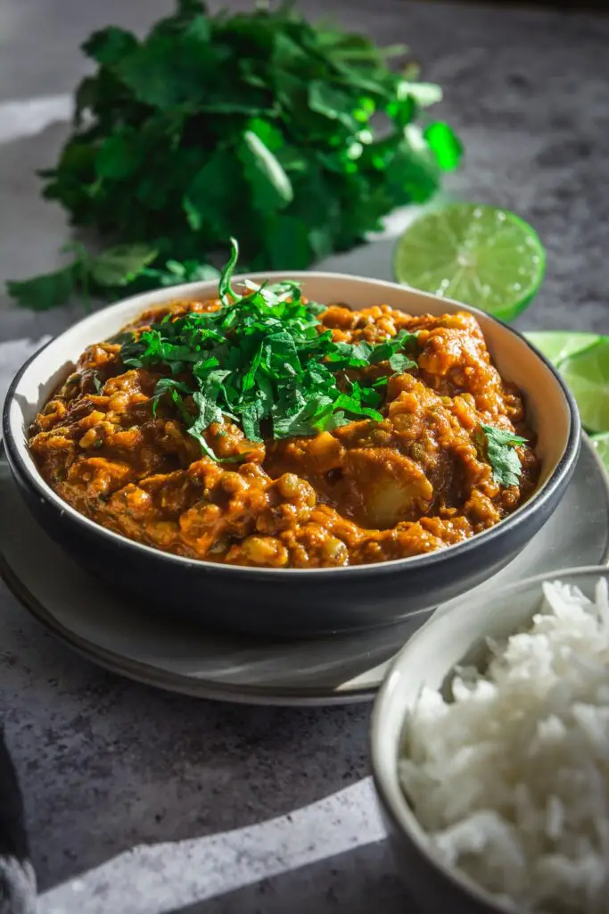 Easy and Healthy Cauliflower Mung Bean Curry on plate with lime and cilantro 