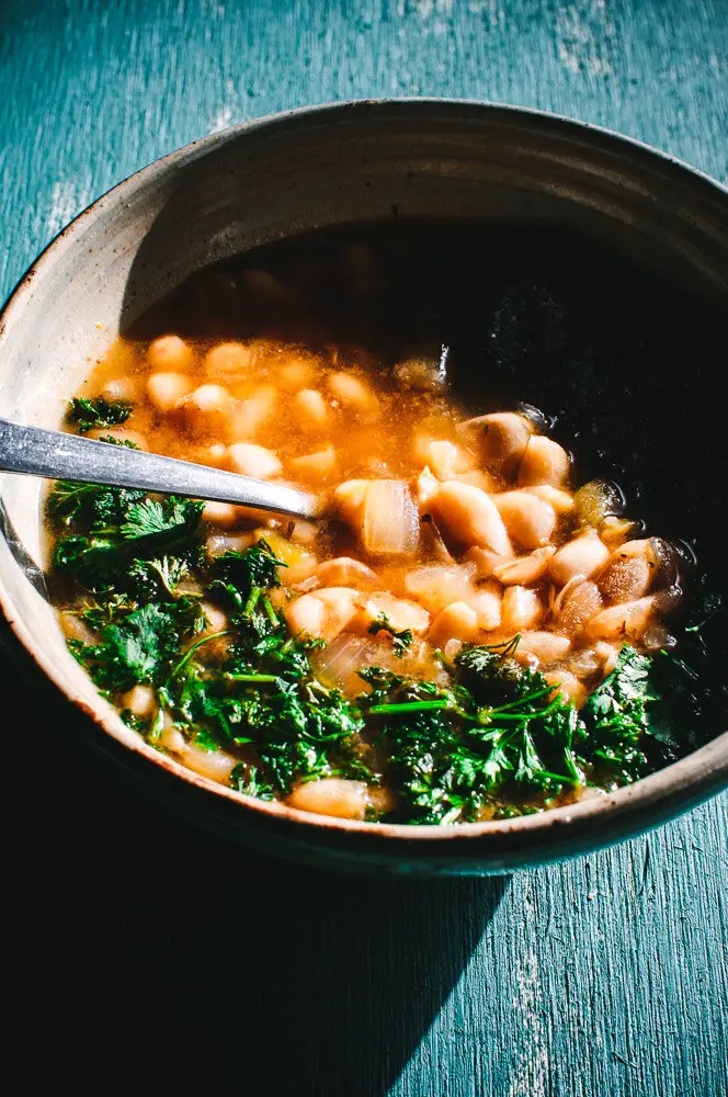 White bean soup in bowl with parsley