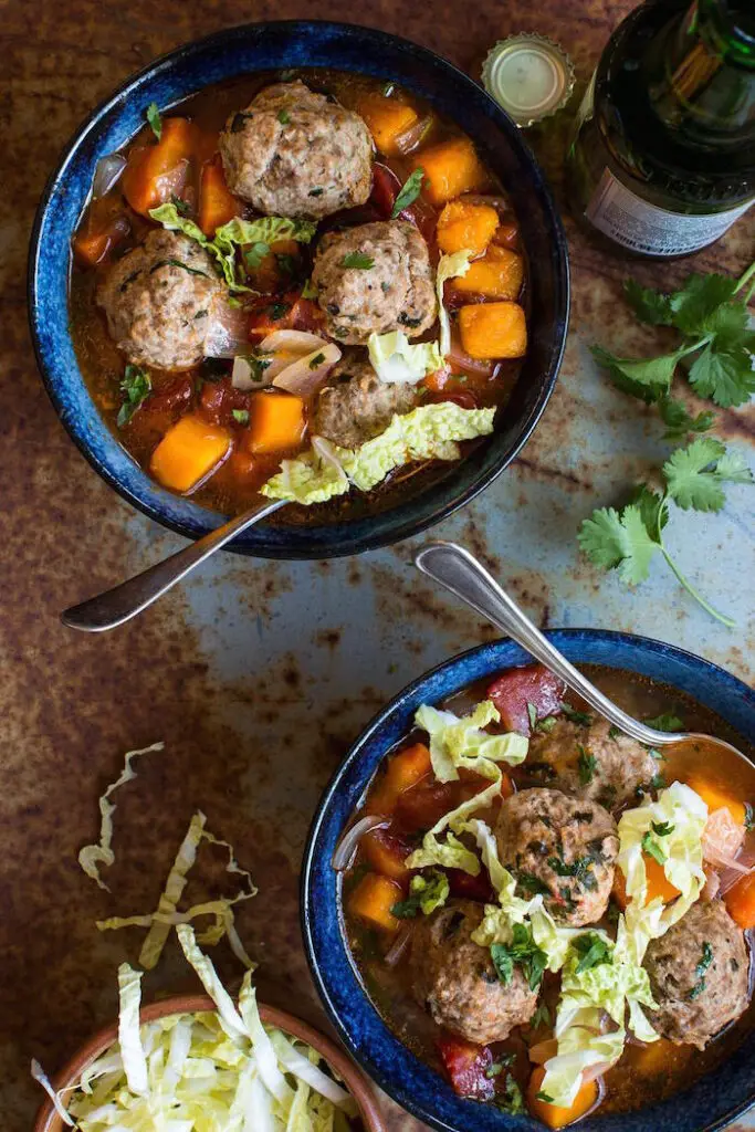 butternut squash soup with meal balls in bowls with spoons