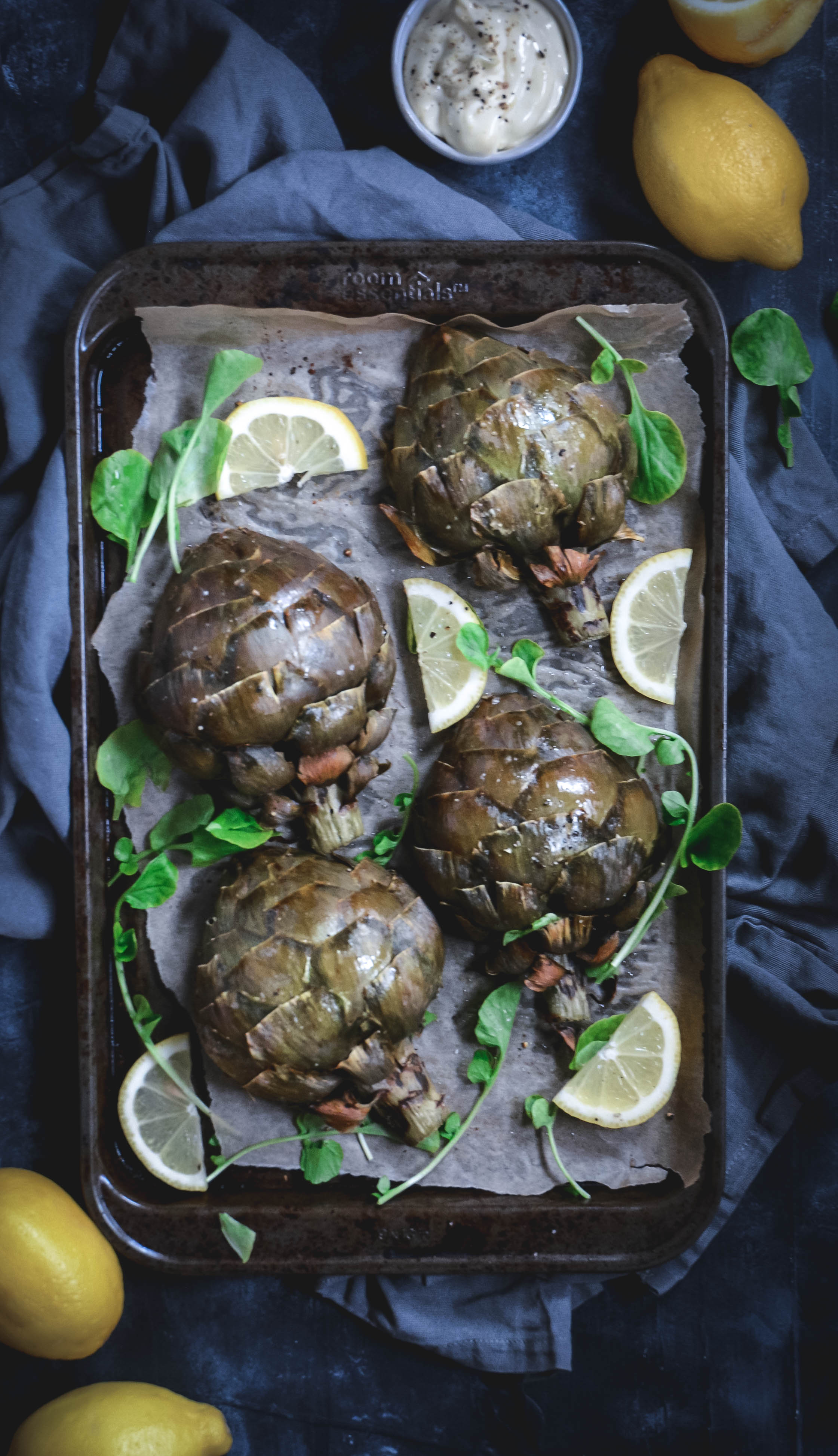 roasted artichokes with lemon slices and lemon aioli and greens