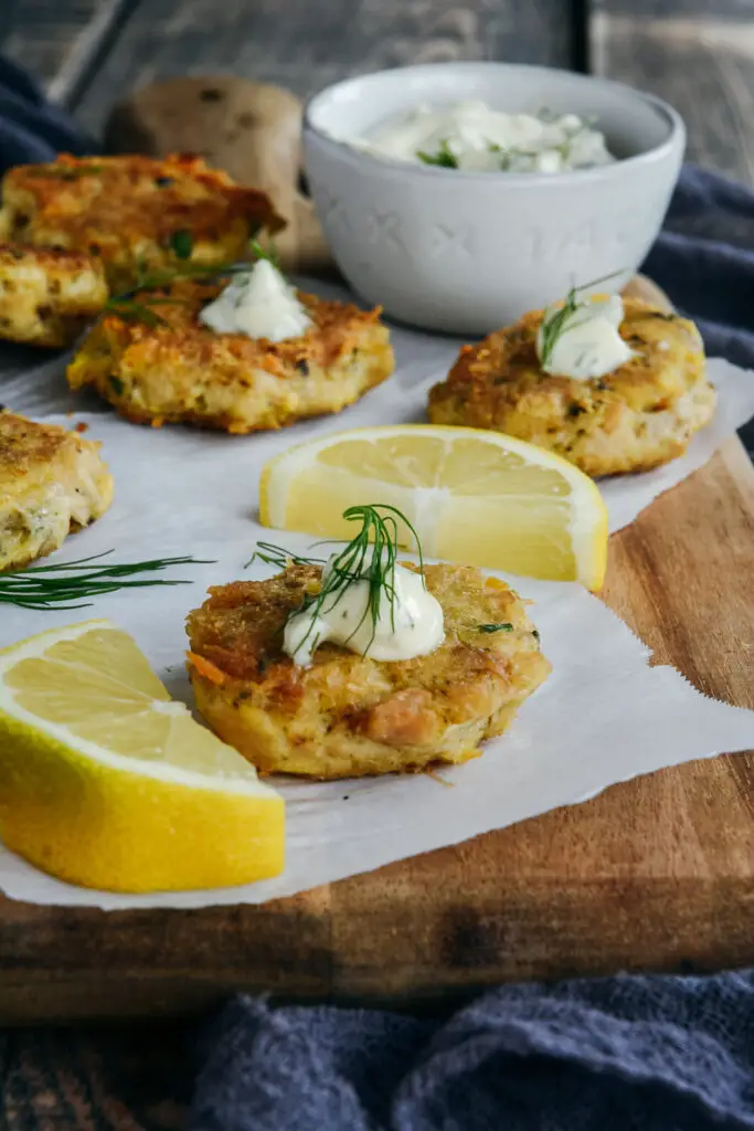 tuna chickpea appetizer bites on cutting board with lemon sauce, dill and bowl or mayo