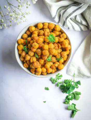 Crispy chickpeas in bowl topped with parsley with baby's breath and napkin