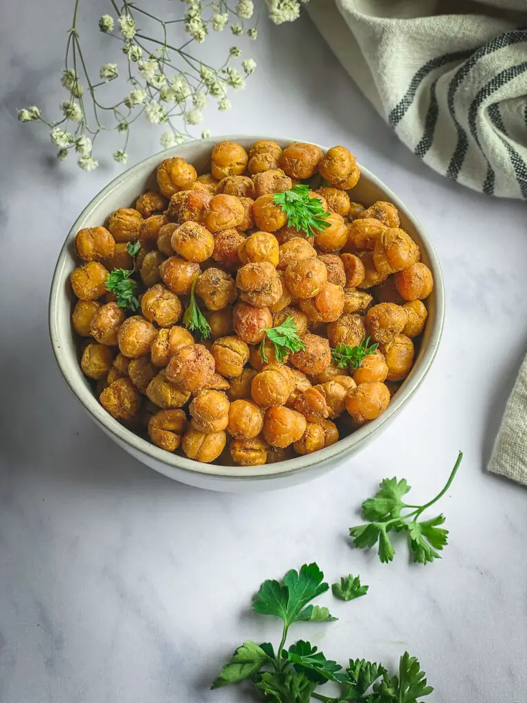 Crispy Roasted Chickpeas in bowl with napkin, and sprinkles with parsley 