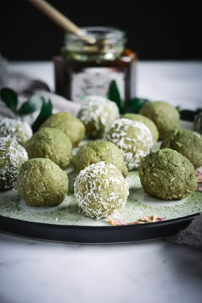 matcha energy balls some covered in shredded coconut on plate