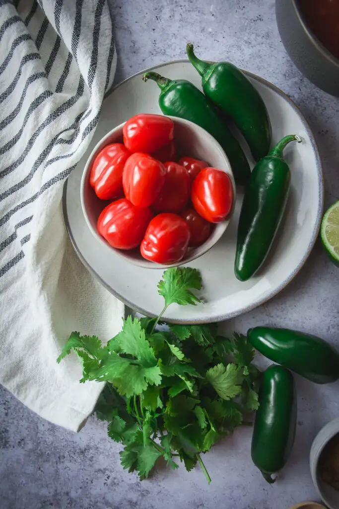 Jalapenos and tomatoes on plate with cilantro lime