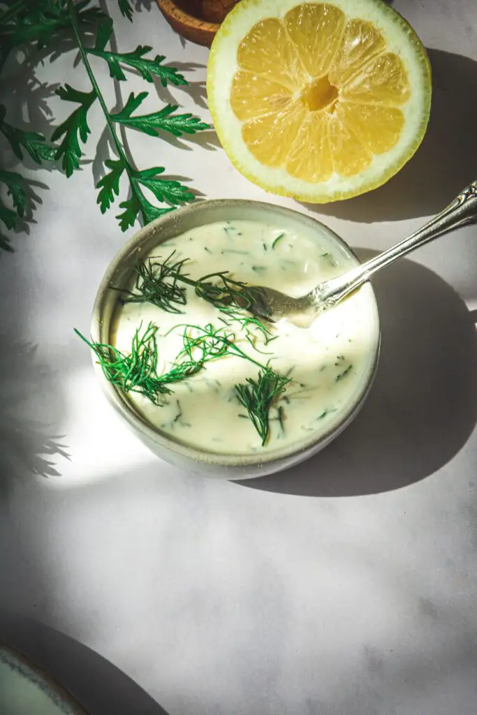 Dill mayo sauce in small bowl with spoon in it