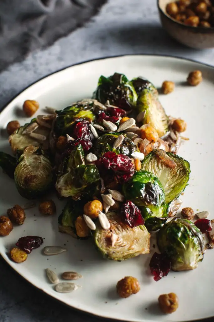 Balsamic Roasted Brussels Spouts with crispy chickpeas, cranberries and sunflower seeds on plate