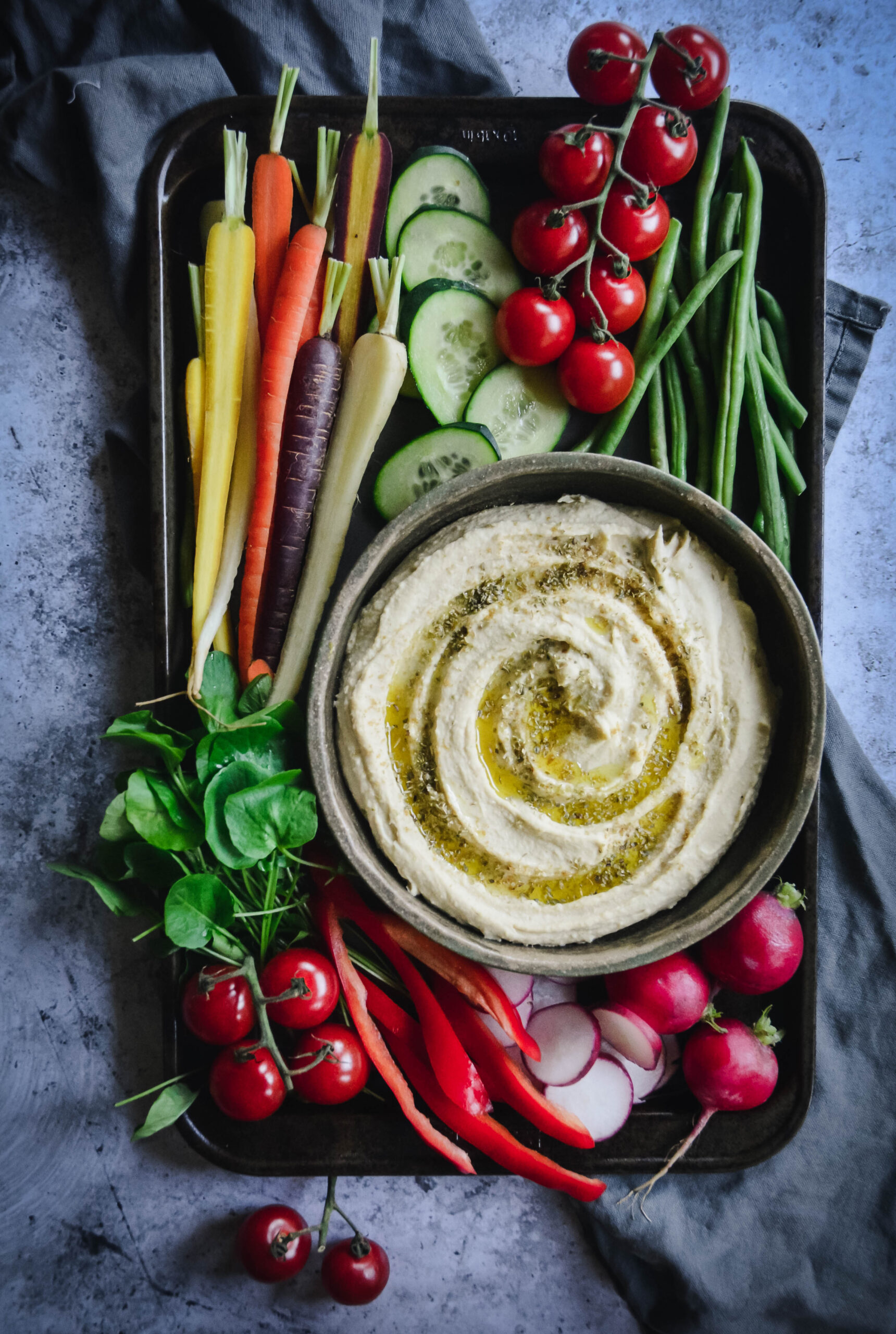 hummus on a plate surrounded by mixed vegetables
