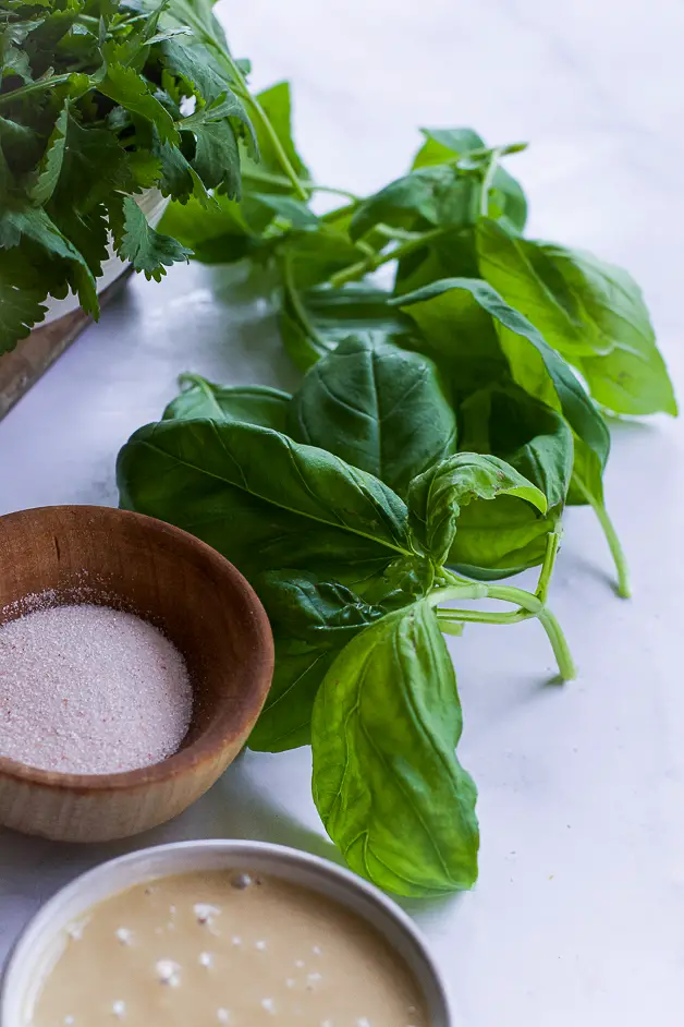 green herbs and a small wooden bowl with salt.