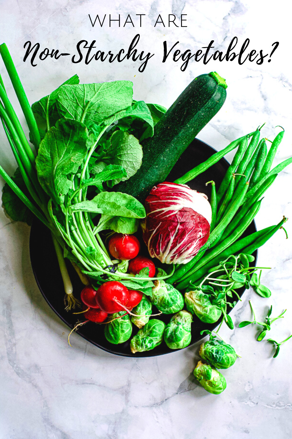 radishes, radicchio, green beans, scallions, brussels sprouts on a black plate