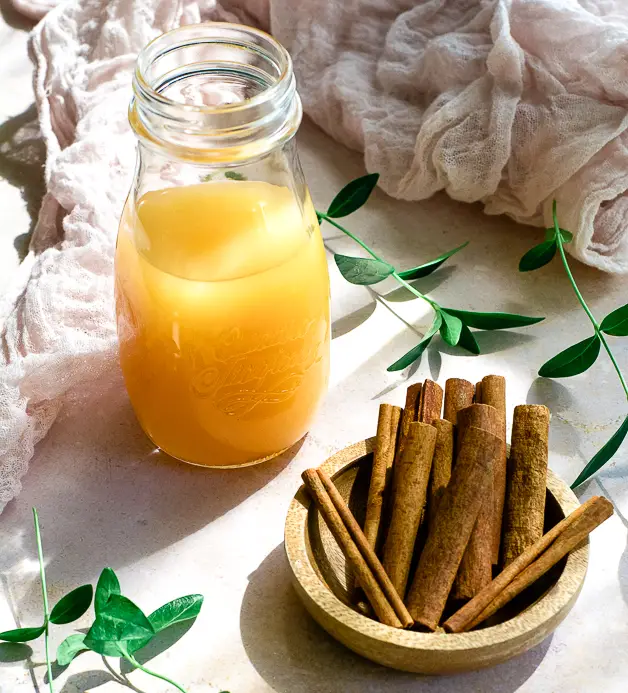 a small bowl of cinnamon sticks, a bottle of apple cider vinegar