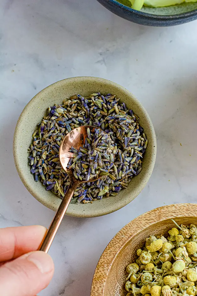 lavender flowers in a small bowl with a spoon