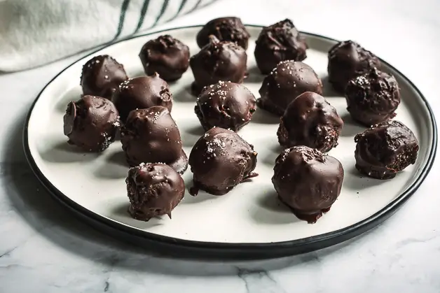 chocolate balls on a white plate on a tabletop