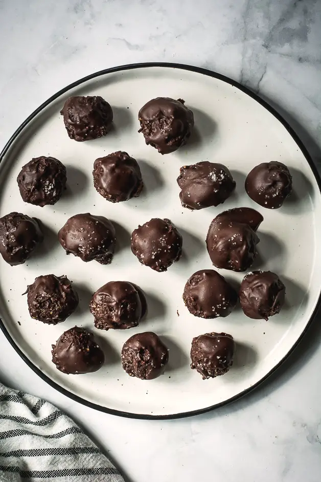 chocolate balls on a white plate on a tabletop from above