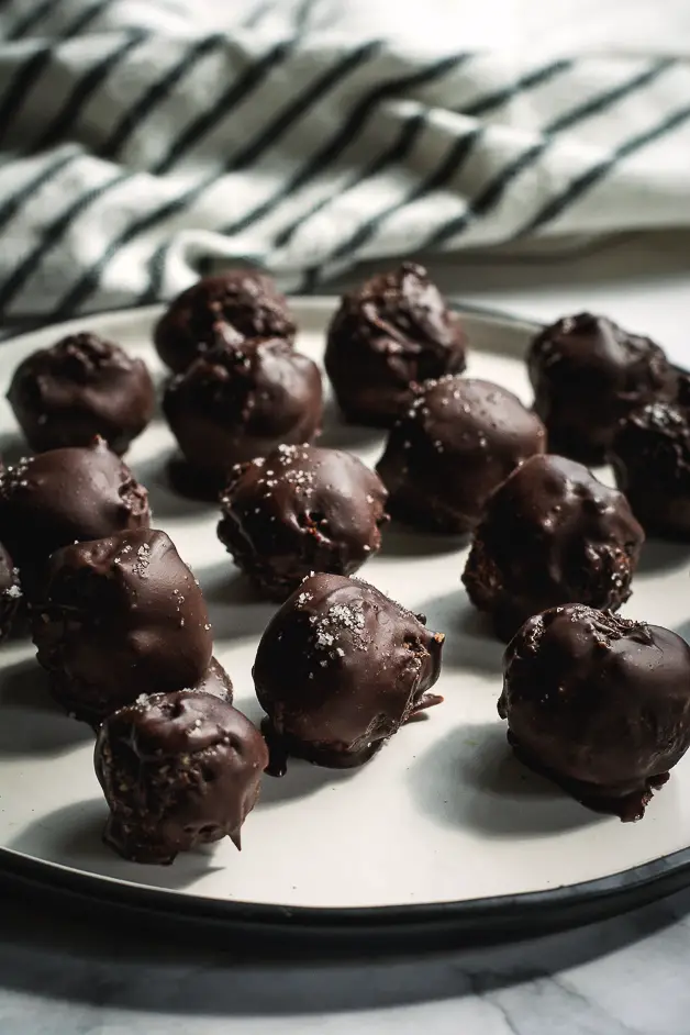 chocolate balls on a white plate on a tabletop