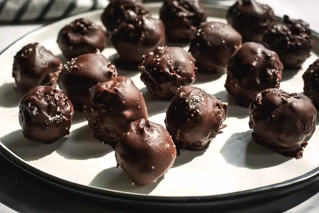 chocolate balls on a white plate on a tabletop side ways shot