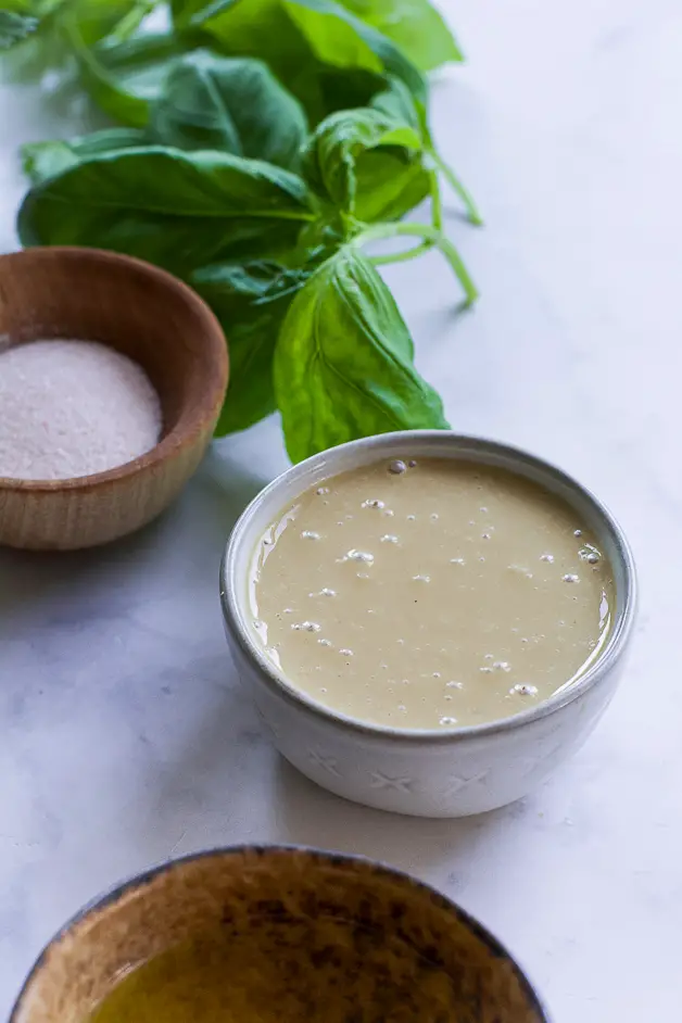 herbs, a small bowl of tahini and a small wooden bowl of salt