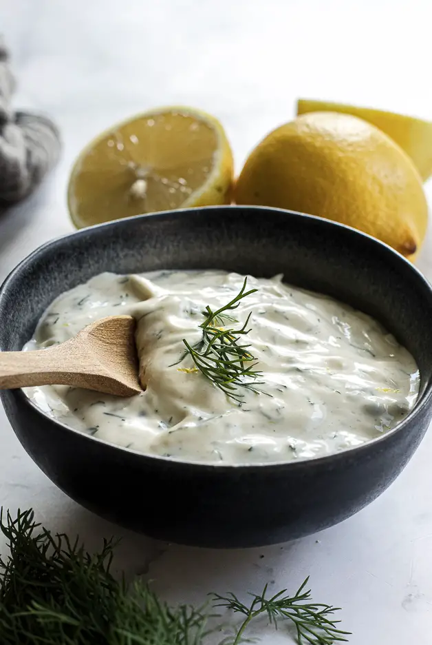 mixed mayo sauce in a bowl with dill and lemons
