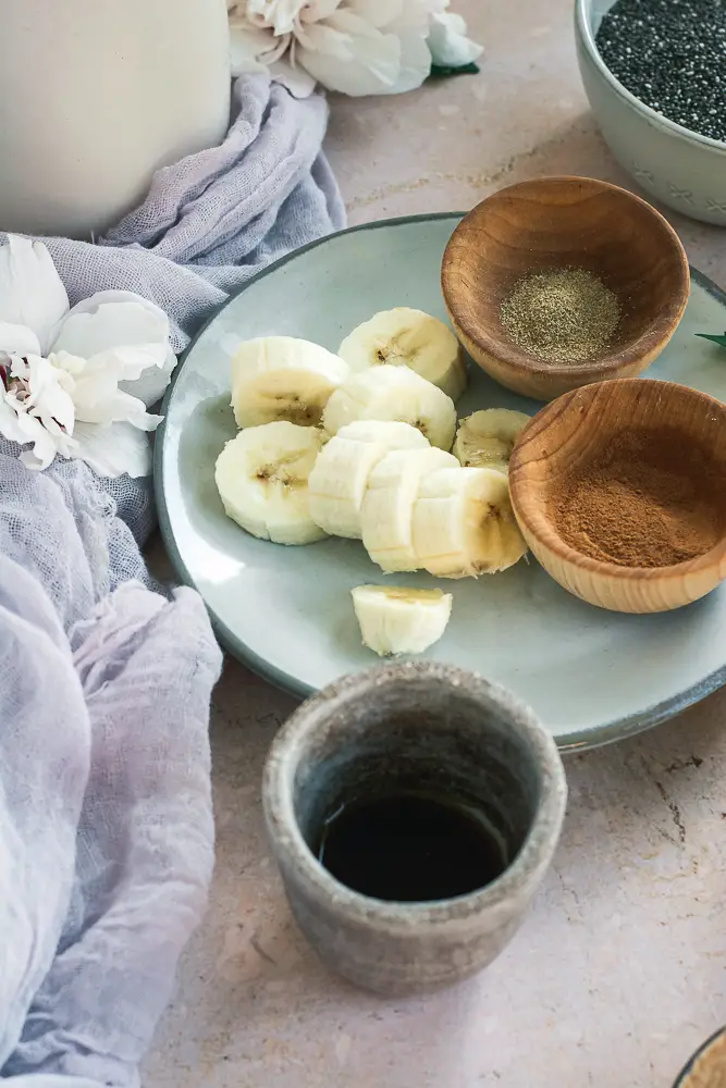 plate with sliced bananas and two wodden small bowls with spices