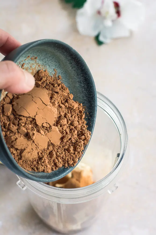 brown cacao powder going into a blender cup