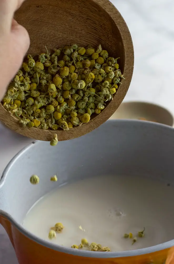 chamomile flowers being added to a pan