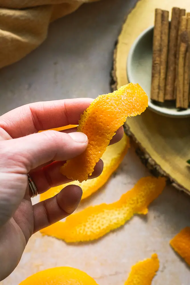 a hand holding a sliver or orange peel