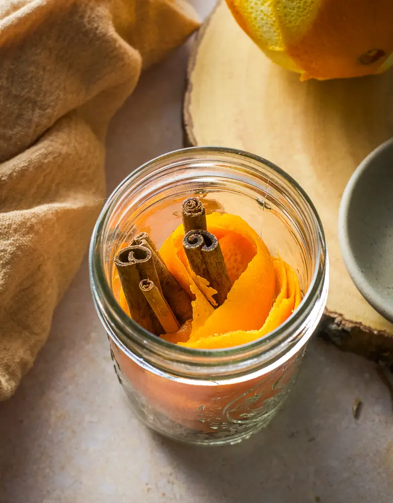orange peels and cinnamon sticks in a jar