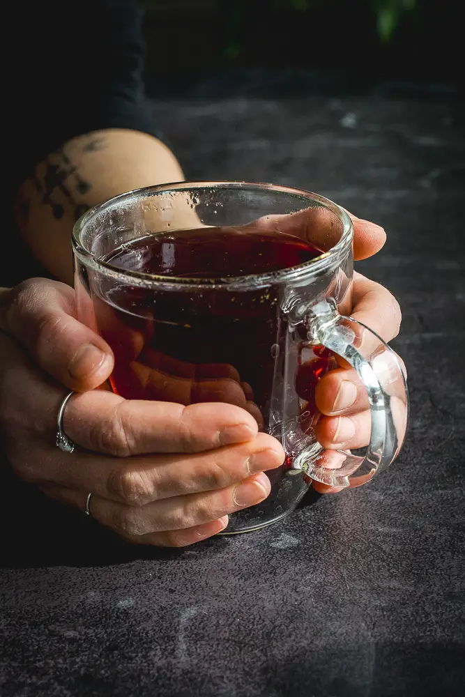 hands holding a cup of red tea