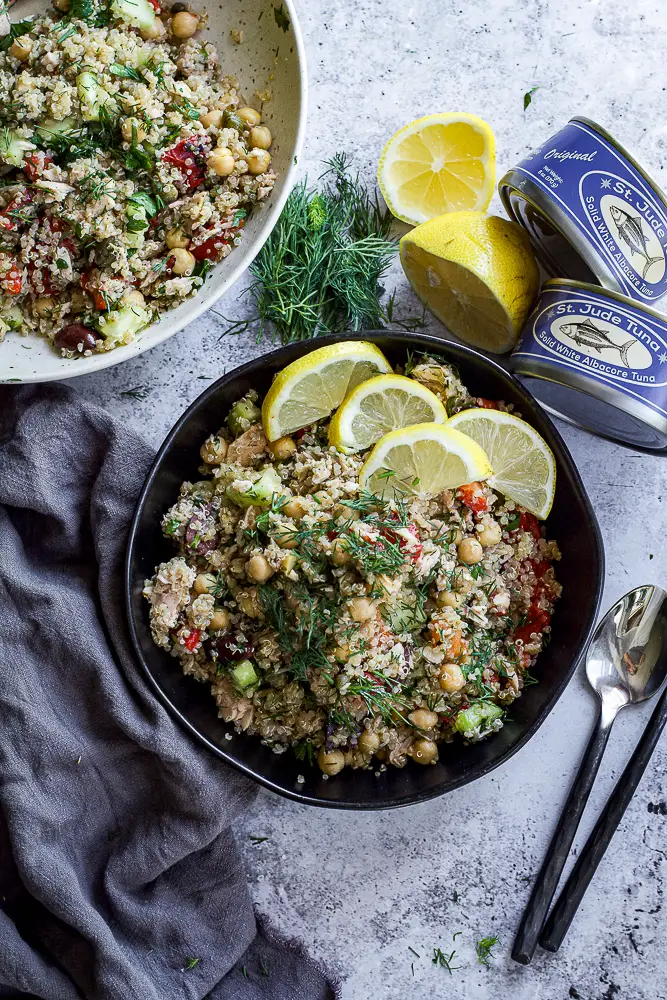 chickpeas and grains in a bowl topped with lemon slices and green herbs