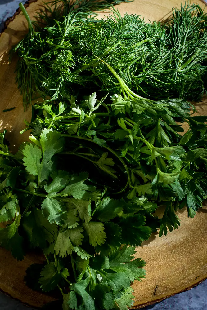 fresh green herbs on a cutting board